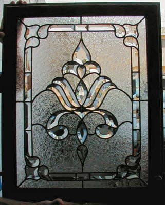 Black-framed beveled-glass panel with clear textured background and a central clear floral fleur motif.